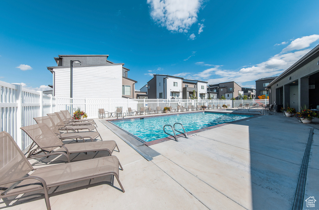 Community pool featuring a patio and a residential view