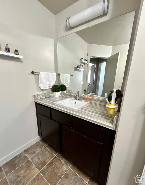 Bathroom with vanity, baseboards, and tile patterned floors
