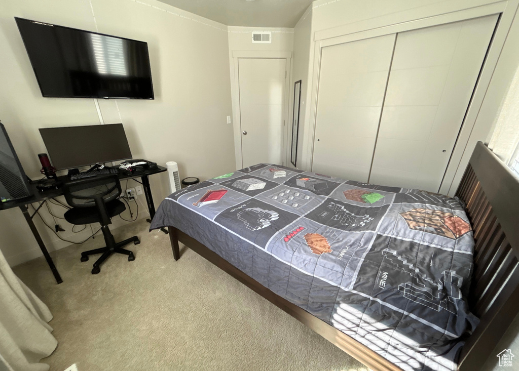Bedroom with carpet flooring, a closet, and a desk