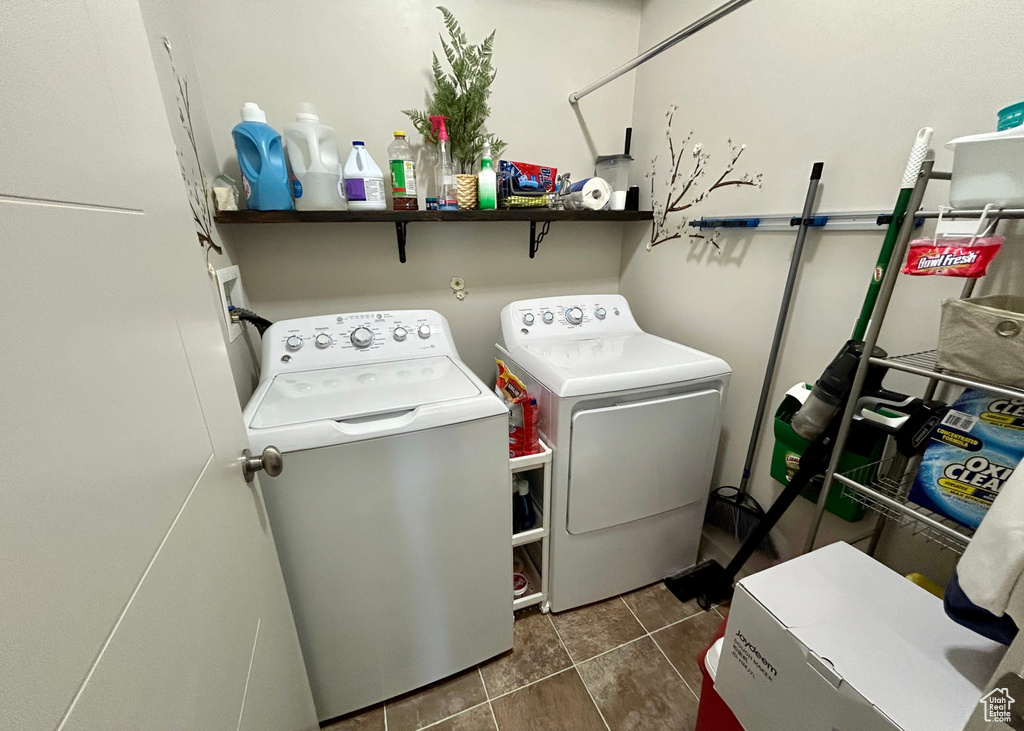 Laundry area with washer and dryer and dark tile patterned flooring