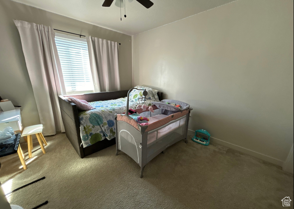 Bedroom with carpet floors, a ceiling fan, and baseboards