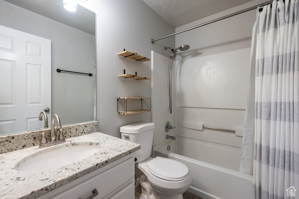 Full bath featuring shower / bath combo, vanity, and toilet