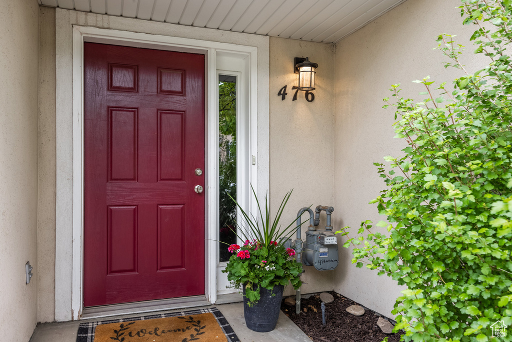Doorway to property with stucco siding and covered porch