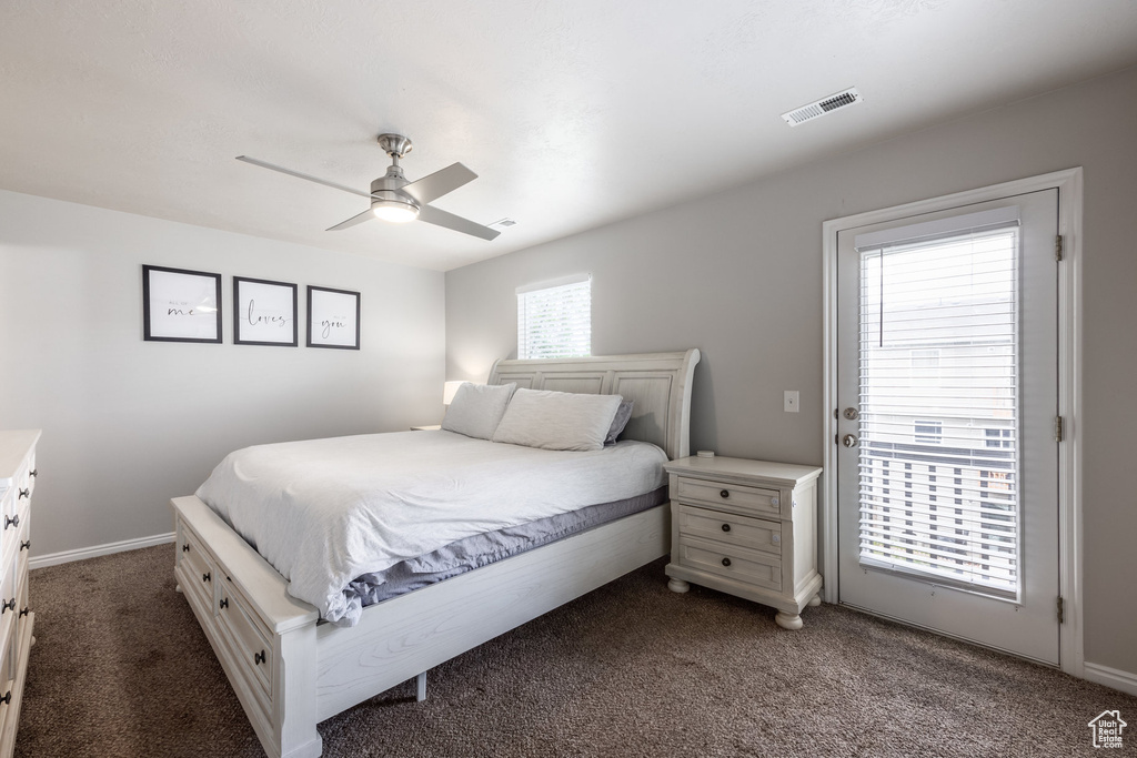 Bedroom featuring dark carpet, ceiling fan, baseboards, and access to exterior