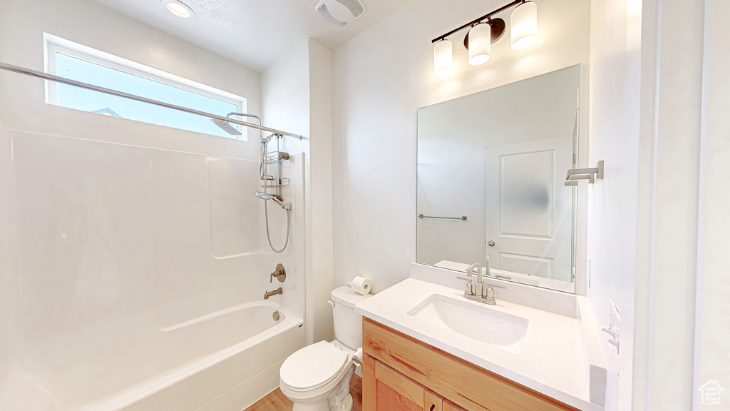 Full bathroom with toilet, vanity, shower / bathtub combination, and wood finished floors