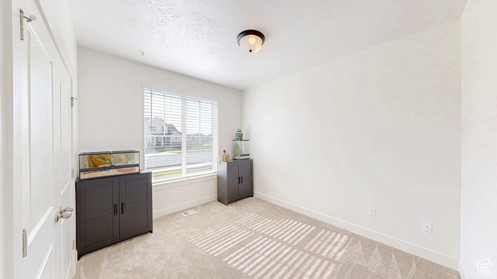 Bedroom featuring light colored carpet and baseboards