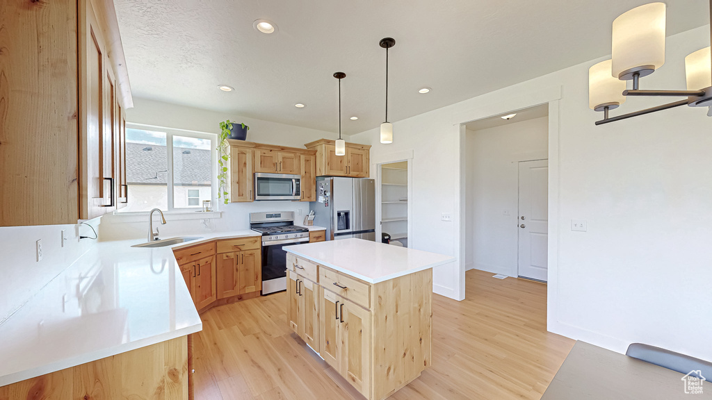 Kitchen with stainless steel appliances, a sink, light wood-type flooring, light brown cabinetry, and recessed lighting
