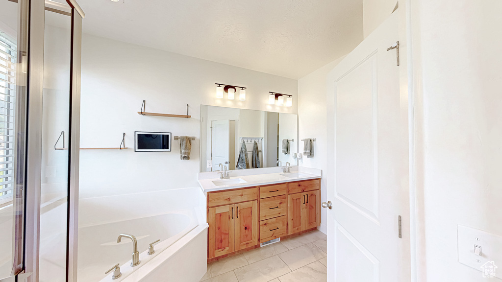 Bathroom featuring a bath and double vanity