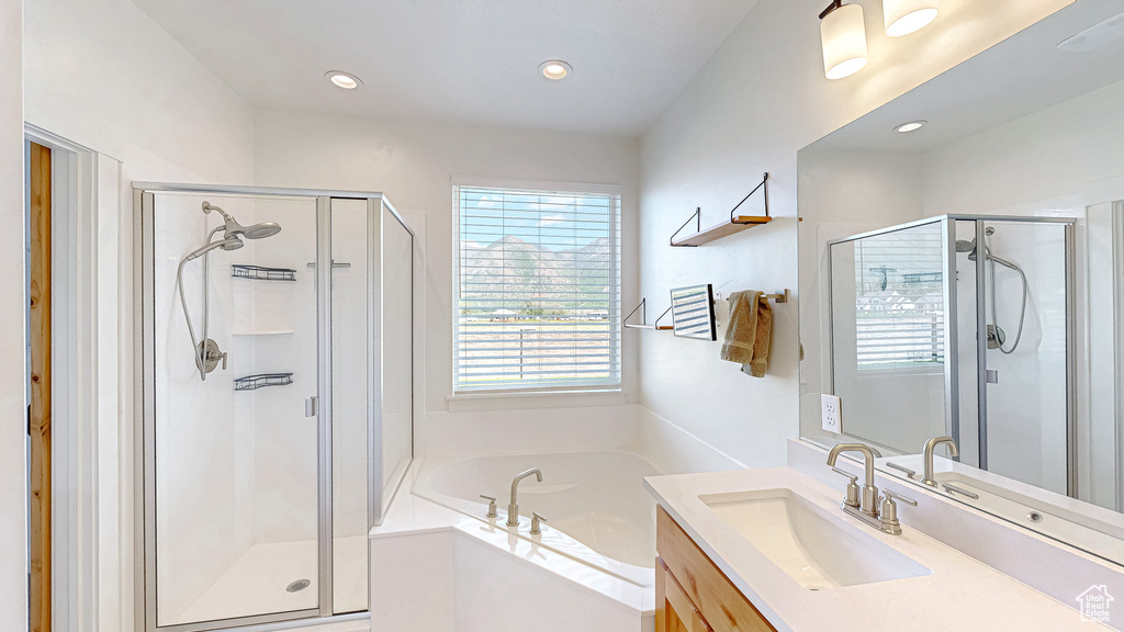 Bathroom with a stall shower, a bath, vanity, and recessed lighting