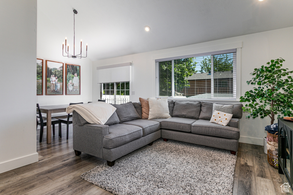 Living area with a chandelier, wood finished floors, baseboards, and recessed lighting
