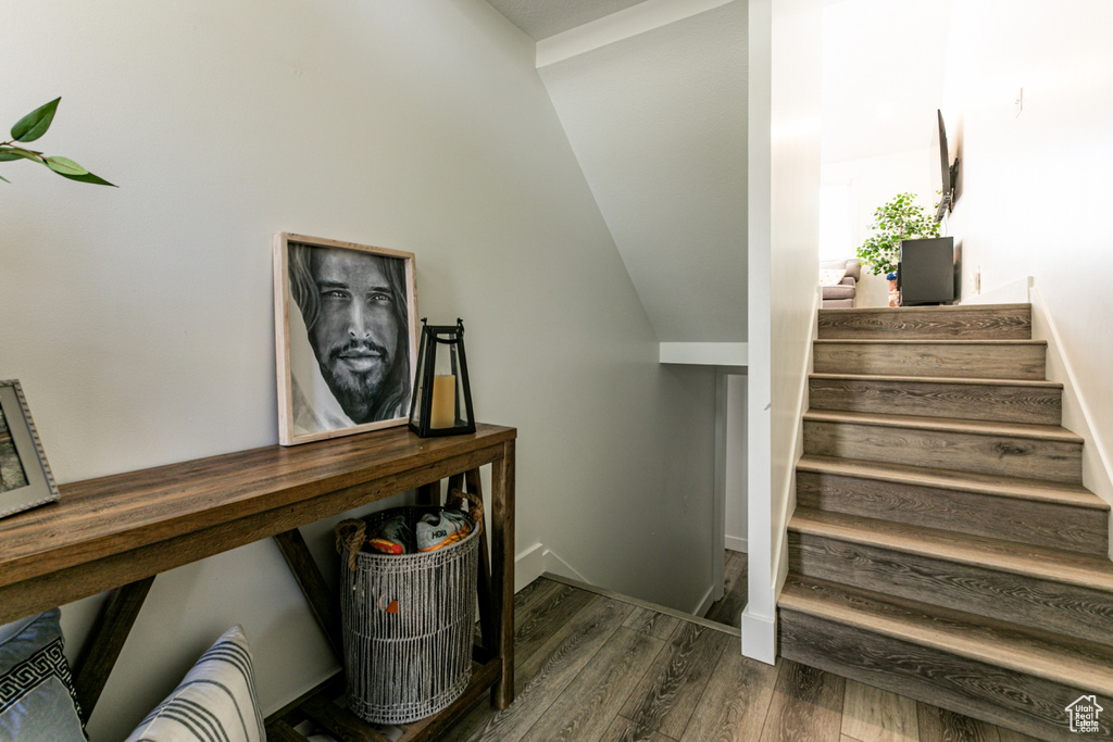 Staircase featuring wood finished floors