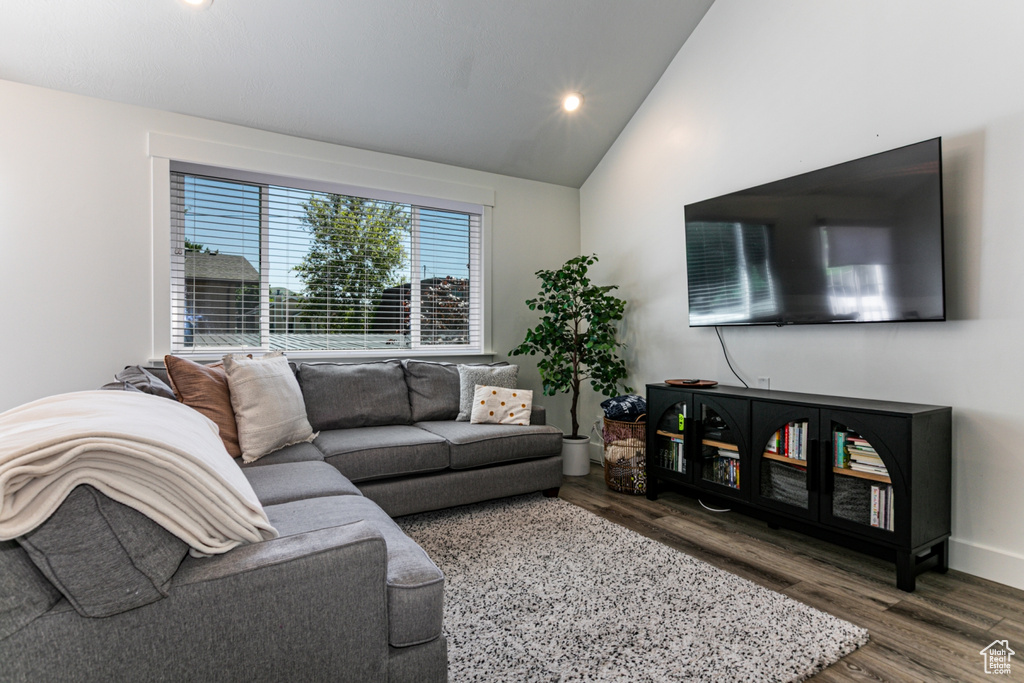 Living area with wood finished floors, recessed lighting, and high vaulted ceiling