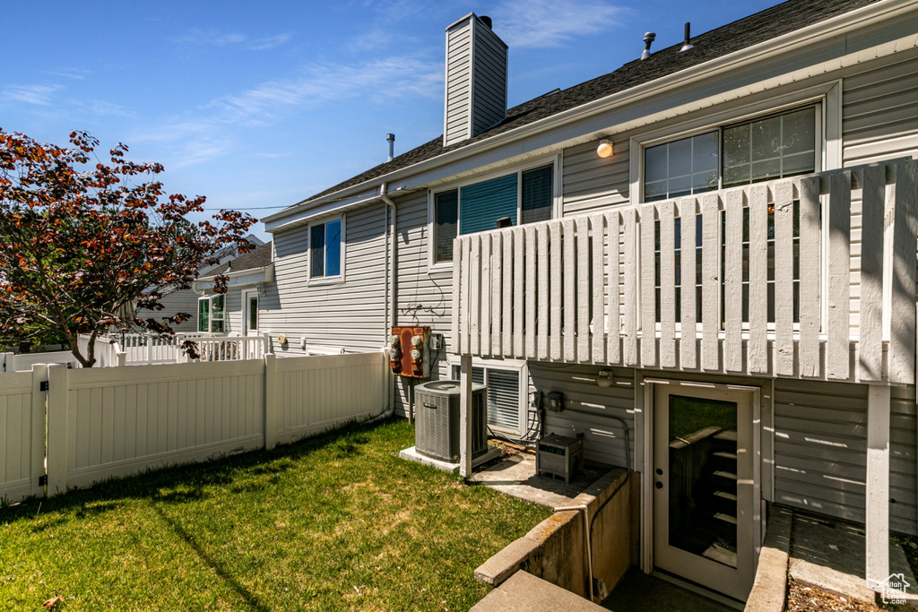 Rear view of house featuring a chimney and central air condition unit
