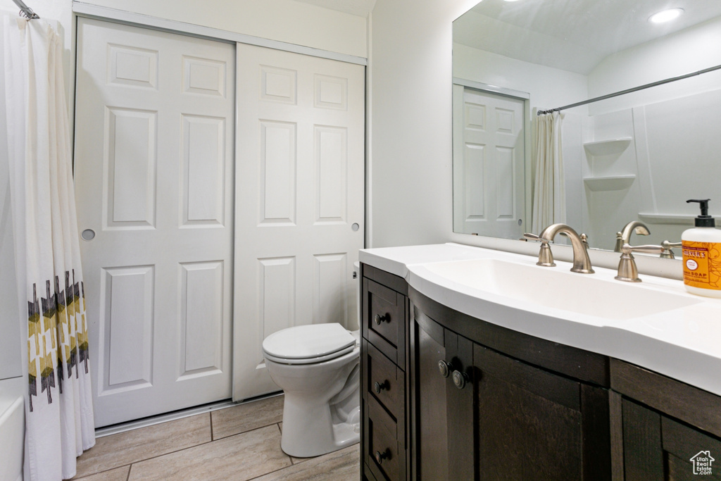 Full bathroom with wood finished floors, vanity, and toilet