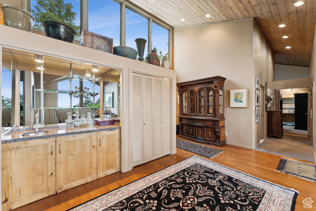 Interior space featuring wooden ceiling, light brown cabinets, a high ceiling, recessed lighting, and plenty of natural light