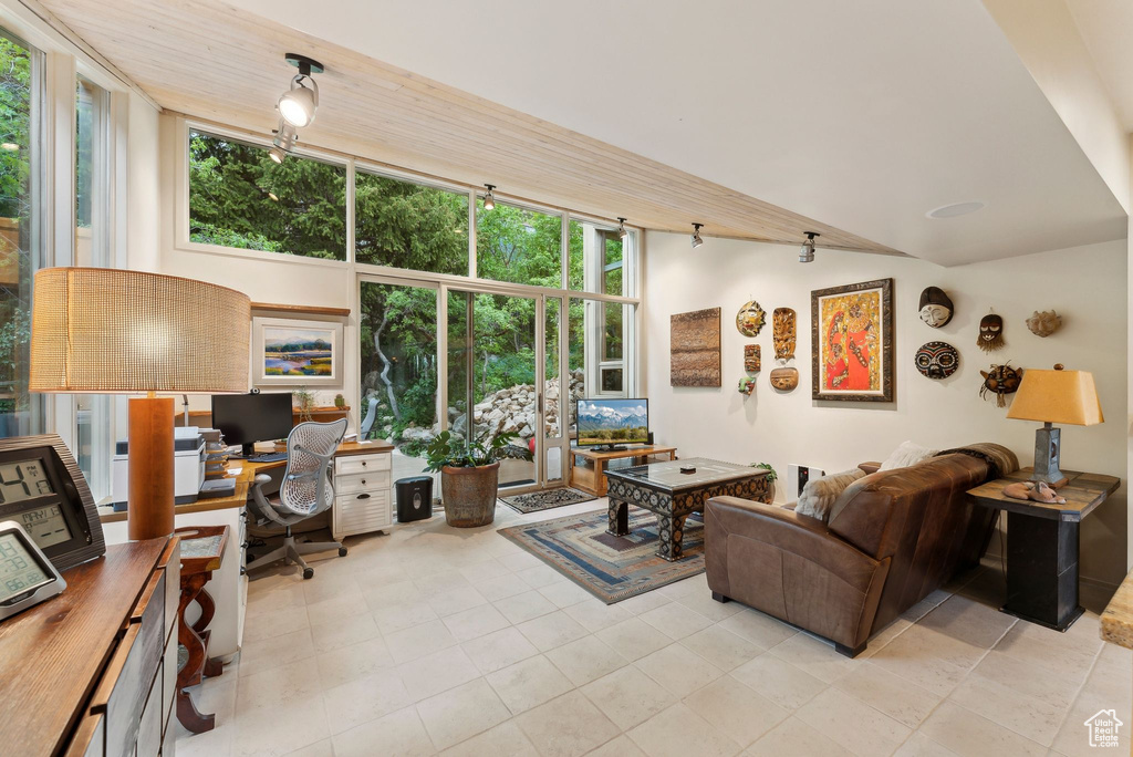 Living area with a desk and light tile patterned flooring