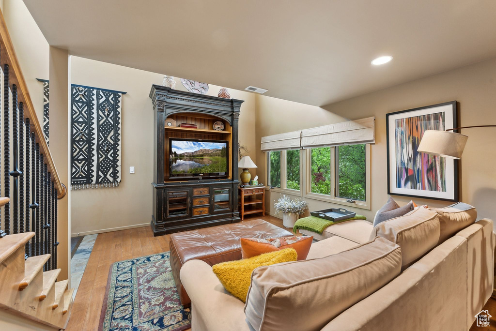 Living area featuring stairway, wood finished floors, recessed lighting, and baseboards