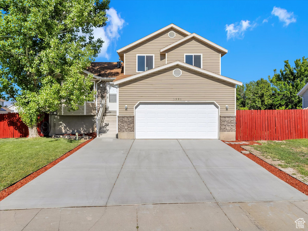 View of front facade featuring brick siding, concrete driveway, and an attached garage
