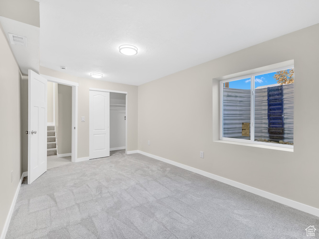 Unfurnished bedroom featuring carpet, baseboards, and a closet