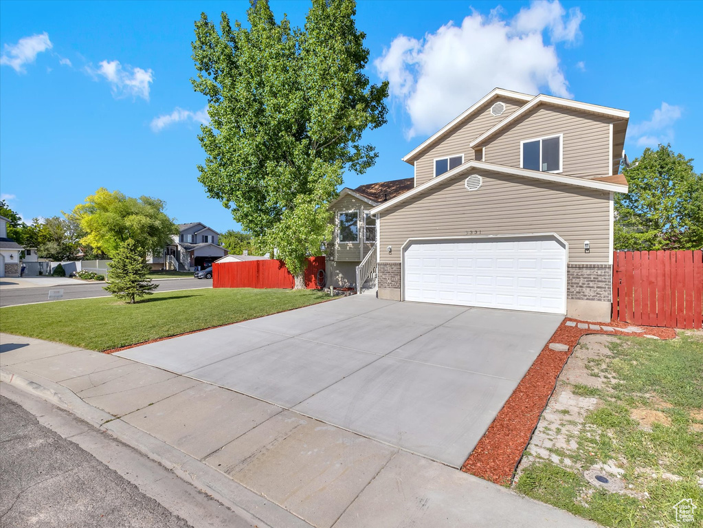 View of front of property featuring brick siding, concrete driveway, and an attached garage
