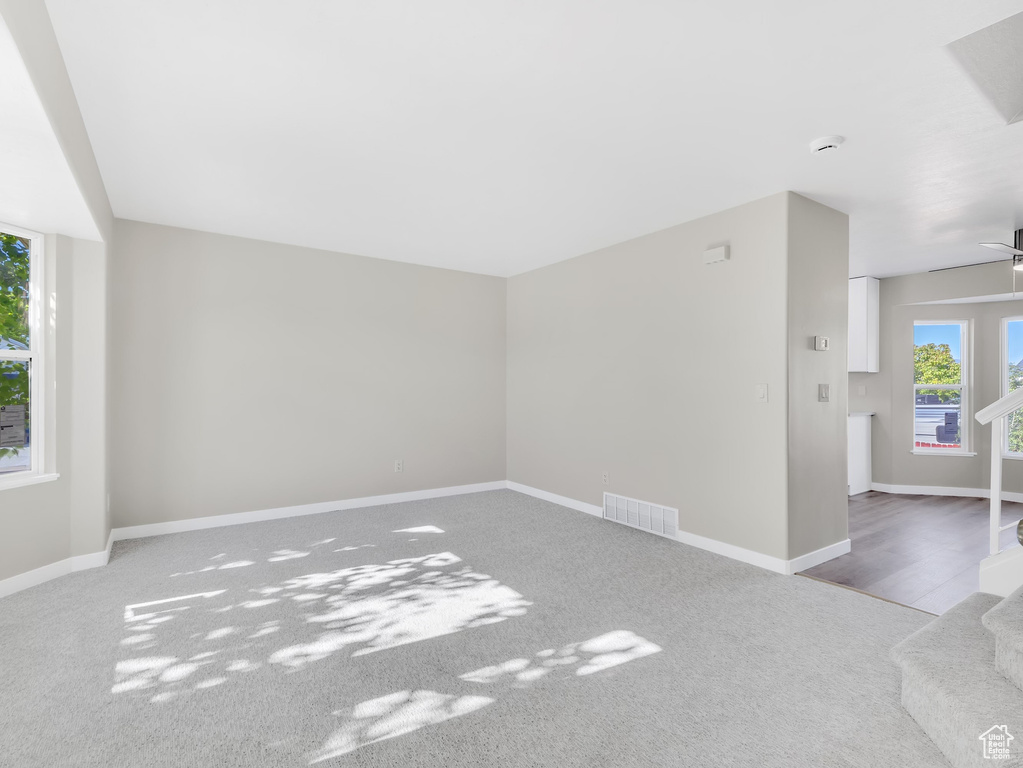 Unfurnished living room with carpet and baseboards