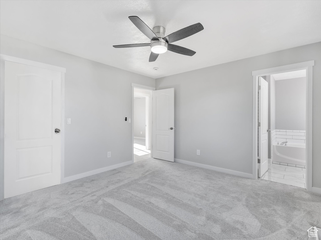Unfurnished bedroom featuring carpet, baseboards, connected bathroom, and a ceiling fan