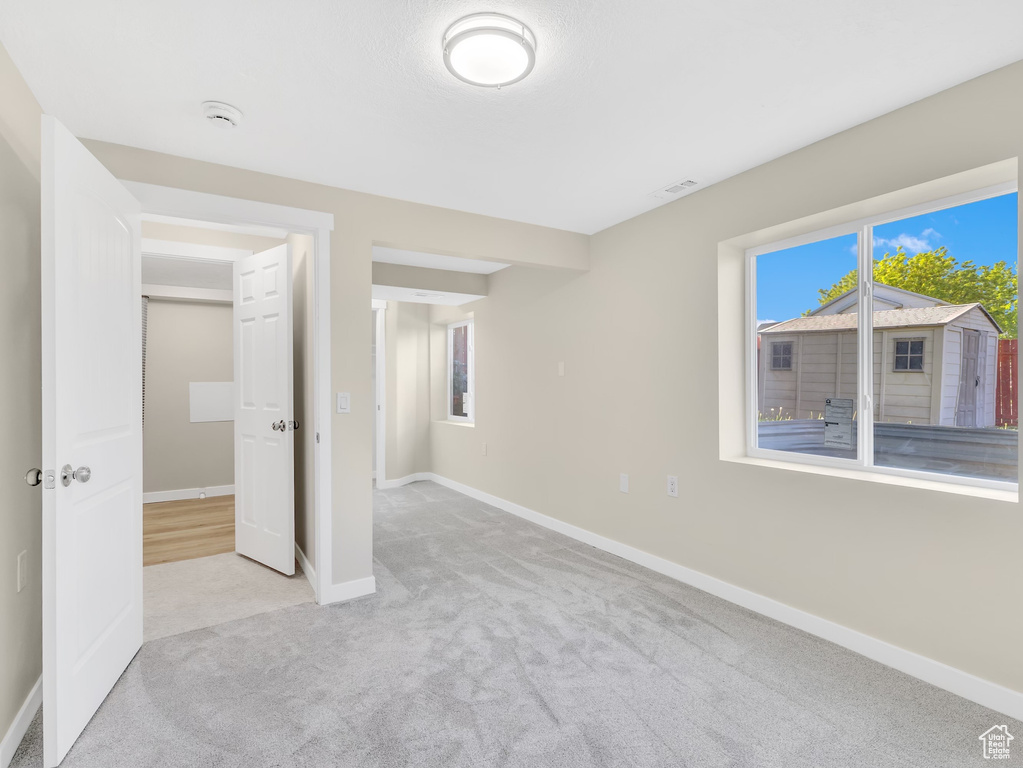 Unfurnished bedroom with carpet flooring, baseboards, and multiple windows