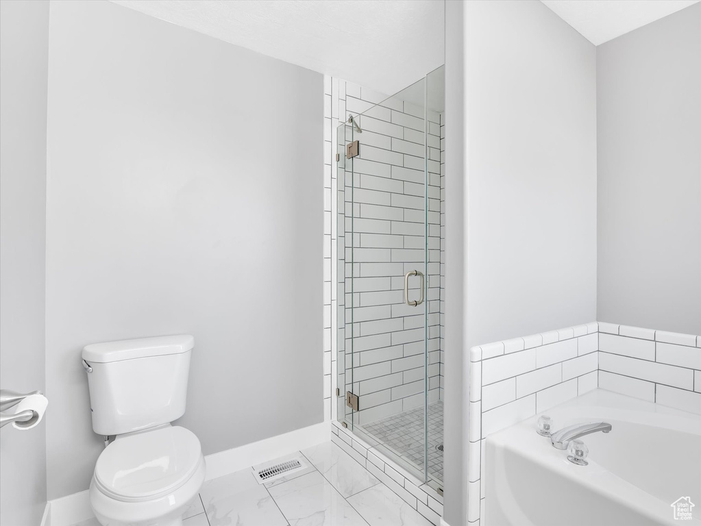 Bathroom featuring baseboards, toilet, a garden tub, a shower stall, and marble finish floors
