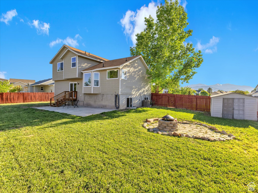 Rear view of property with an outdoor fire pit, a patio, and central AC