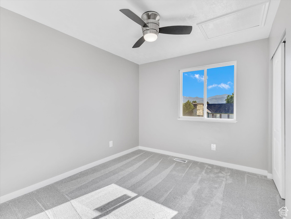Spare room with a ceiling fan, carpet, and baseboards
