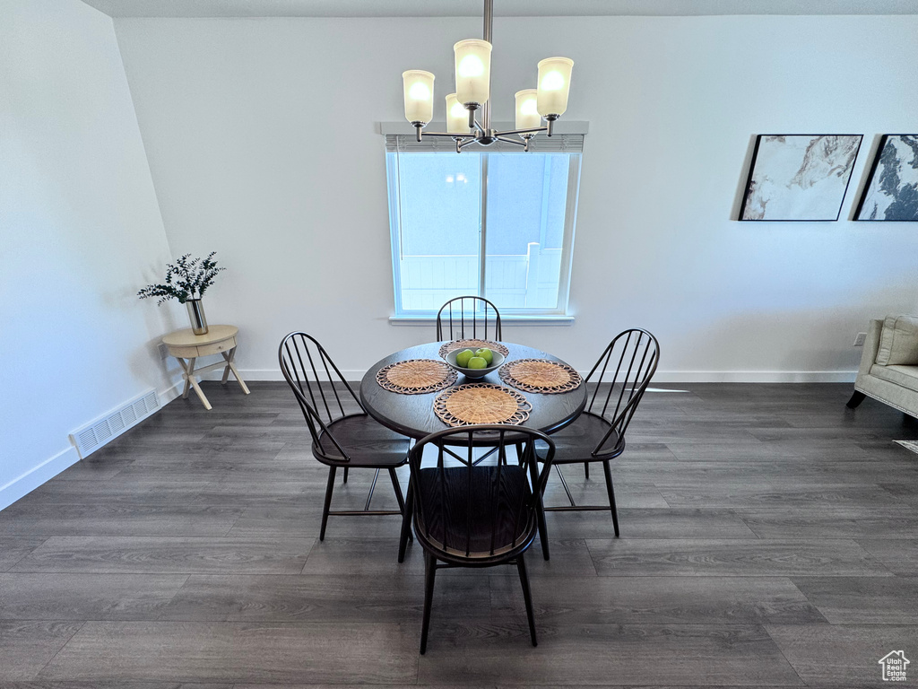 Dining room with a chandelier, dark wood-type flooring, and baseboards