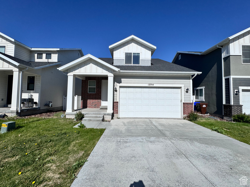 View of front of home featuring brick siding, board and batten siding, a porch, concrete driveway, and a garage