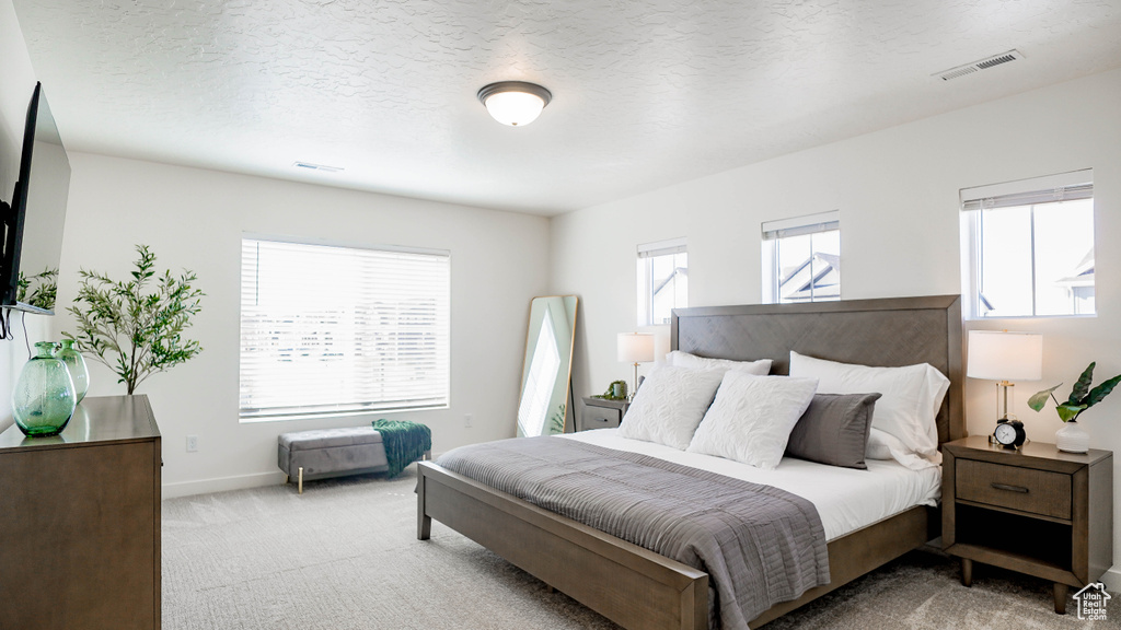 Bedroom featuring light carpet and baseboards