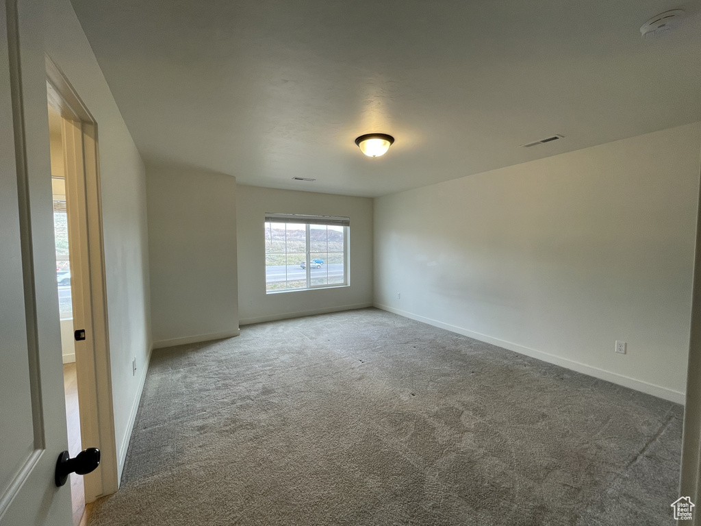 Carpeted empty room with baseboards