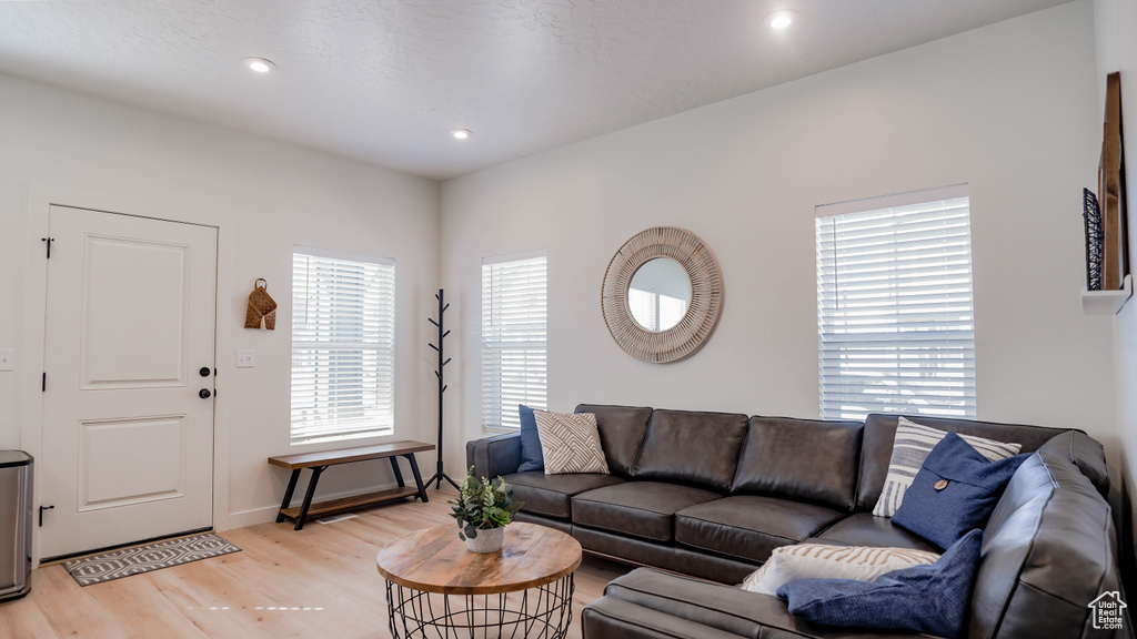 Living room with light wood-style flooring, recessed lighting, and baseboards