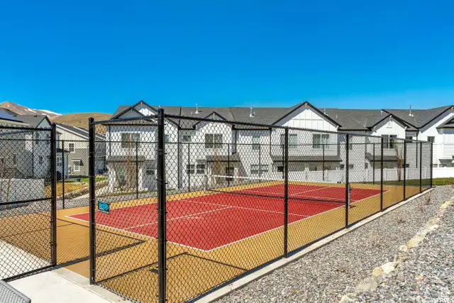 View of sport court featuring a tennis court and a residential view