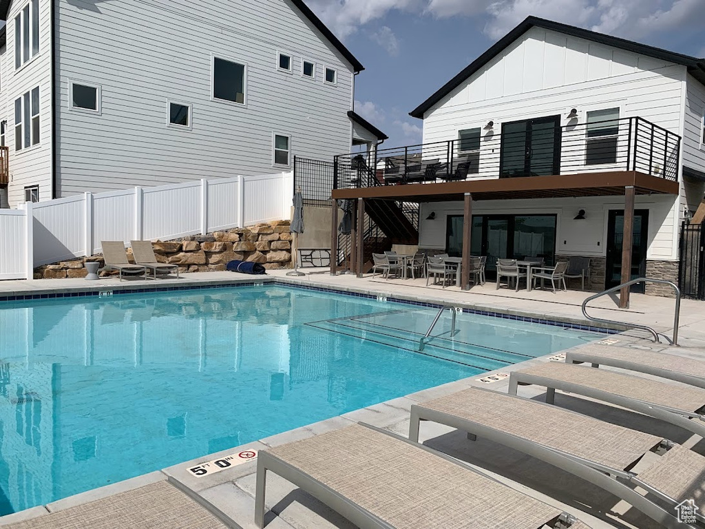 Community pool with stairway, a patio, and a wooden deck