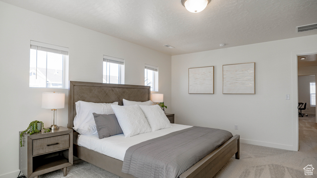 Bedroom with baseboards and light colored carpet