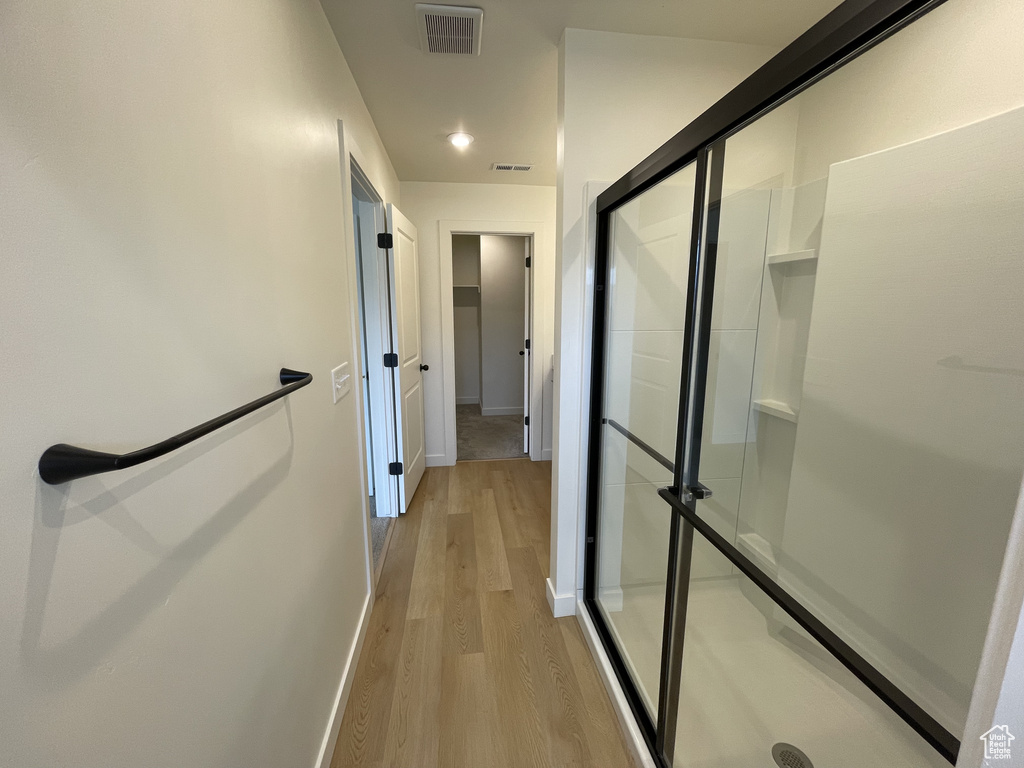 Hall with light wood-style floors and baseboards