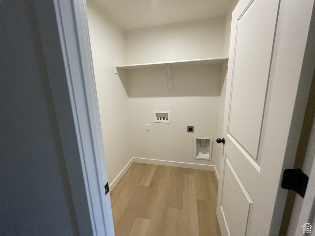 Laundry room featuring hookup for a washing machine, hookup for an electric dryer, light wood-style flooring, and baseboards