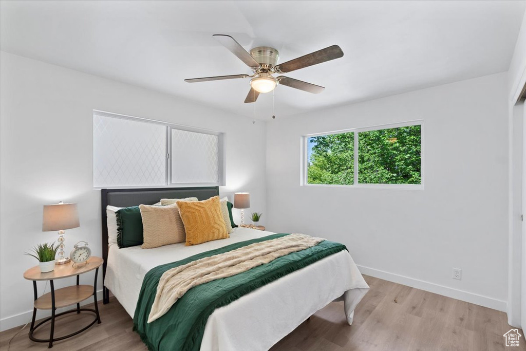 Bedroom with baseboards, light wood-style floors, and a ceiling fan