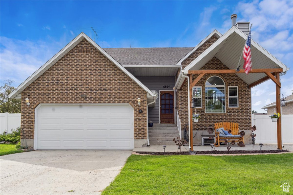 View of front facade featuring brick siding, concrete driveway, an attached garage, a chimney, and roof with shingles