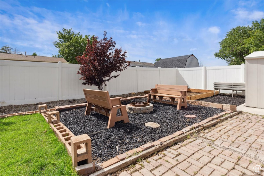 Fenced backyard featuring an outdoor fire pit and a patio area