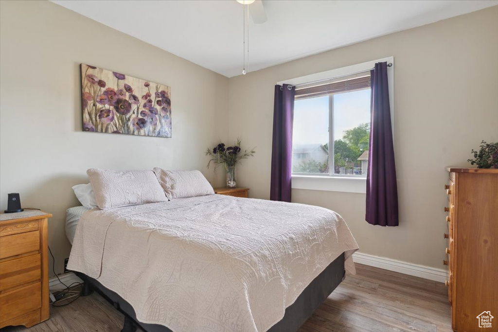 Bedroom with wood finished floors, baseboards, and ceiling fan