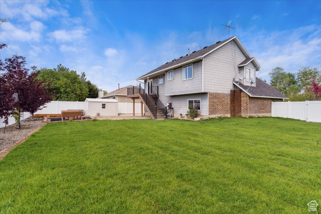 Back of house featuring stairway and brick siding