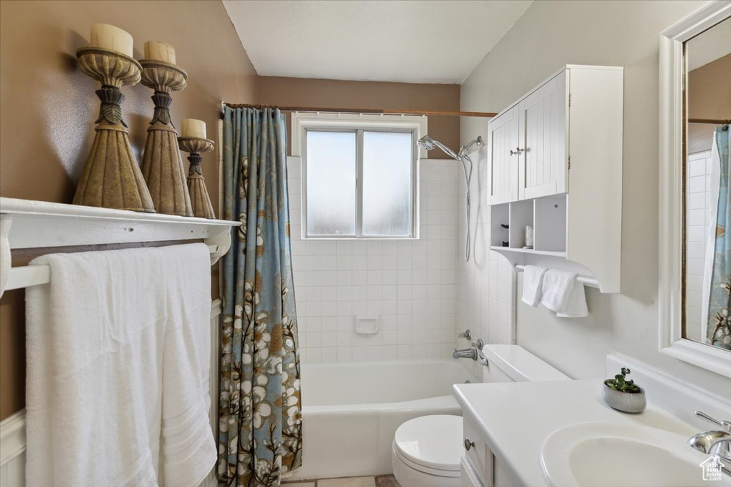 Bathroom with toilet, shower / bath combination with curtain, and vanity