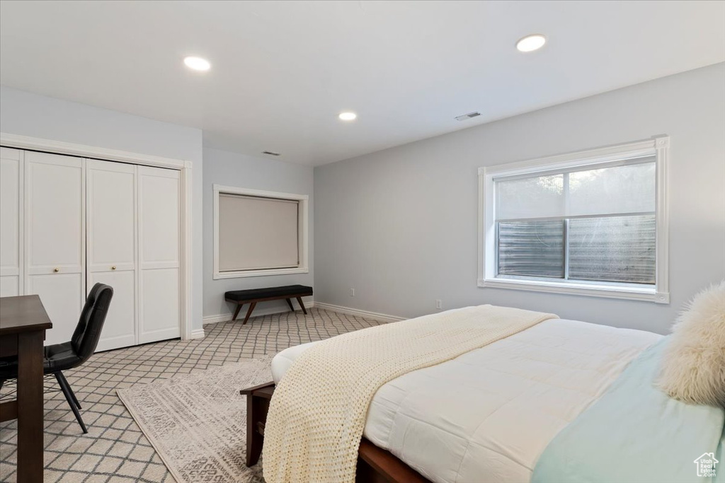 Bedroom featuring light colored carpet, recessed lighting, baseboards, and a closet