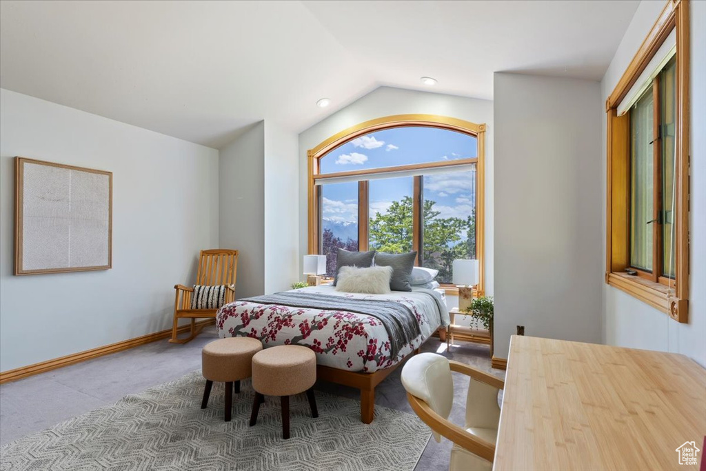 Bedroom with vaulted ceiling, carpet floors, and baseboards