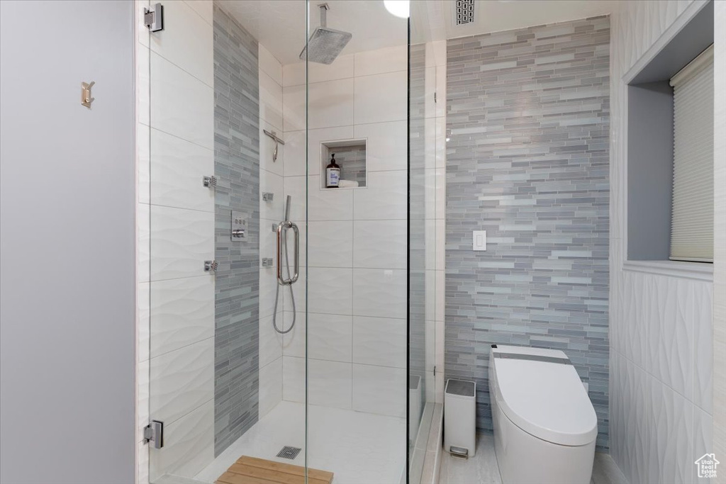 Full bath with toilet and a shower stall