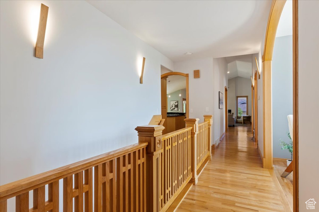 Hallway with light wood-style flooring and an upstairs landing